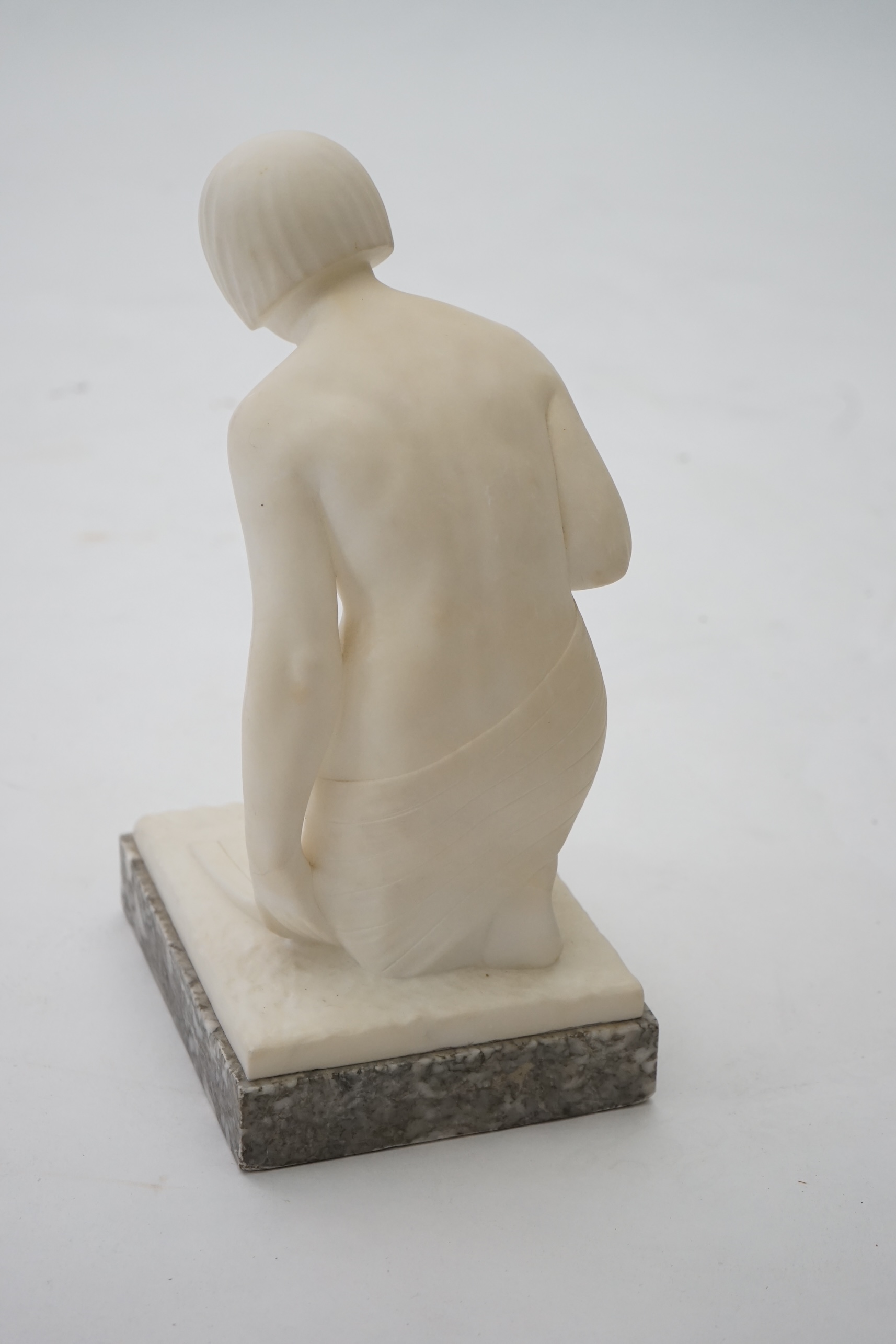 Manner of Gugliemo Pugi (1850-1915). An Italian Art Deco carved marble figure of a crouching bather kneeling and semi-draped